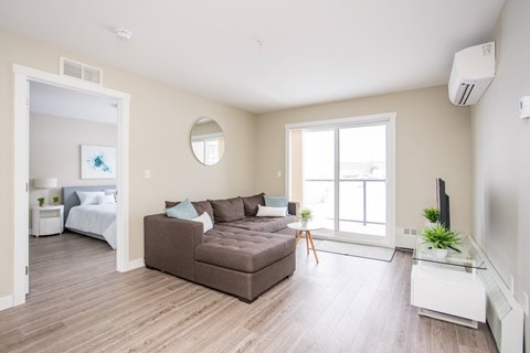 a living room with a couch and a table     and a bedroom